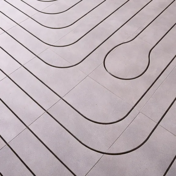 Ein gefliester Boden mit gleichmäßig verteilten, geschwungenen schwarzen Linien, die ein geometrisches Muster bilden. Eine Linie bildet eine abgerundete Schleife, die sich von dem regelmäßigen Muster aus parallelen Kurven abhebt.